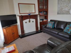 a living room with a couch and a flat screen tv at Addies Place Goolwa in Goolwa