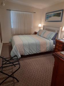 a bedroom with a bed and a chair in it at Addies Place Goolwa in Goolwa