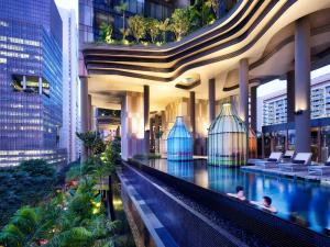 a hotel swimming pool in a building with people in it at PARKROYAL COLLECTION Pickering, Singapore in Singapore