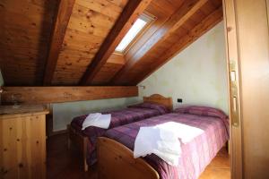 a bedroom with two beds in a attic at Residence Casa Federica in Valfurva