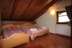 sypialnia z 2 łóżkami i oknem w pokoju w obiekcie Residence Casa Federica w mieście Valfurva