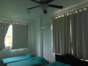 1 dormitorio con ventilador de techo y 1 cama en Villa Yalirocu, en Carretal