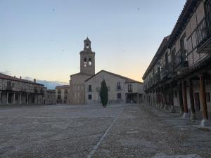 un edificio con una torre de reloj en medio de una calle en Casa Santa Maria I con barbacoa, en Arévalo
