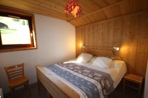 Un dormitorio con una cama en una habitación con ventana. en Le Chalet de Bisanne, en Les Saisies