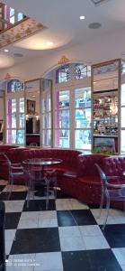 a restaurant with a red couch and tables and windows at Alojamiento Buciero in Santoña