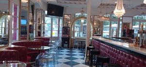 a restaurant with a bar with red chairs and tables at Alojamiento Buciero in Santoña