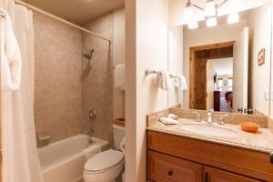 a bathroom with a tub and a sink and a toilet at Treetops Access to Eagle Bahn Gondola in Vail +7 photos