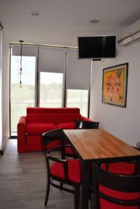 a living room with a red couch and a table at Destino Los Tachos in Mar del Plata