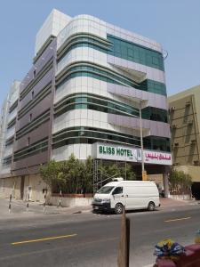 uma carrinha branca estacionada em frente a um edifício em BLISS HOTEL L.L.C em Dubai