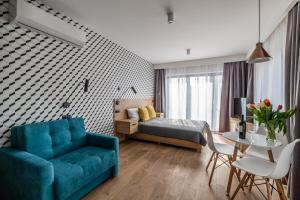 a bedroom with a blue couch and a bed and a table at Krakow Square Residence in Krakow