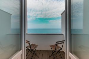two chairs on a balcony with a view of the ocean at Taliammari in Cefalù
