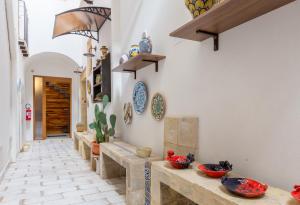a kitchen area with a table, chairs, and a clock at Casa dell'Aromatario b&b in Sciacca
