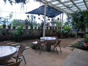 un patio con tavolo, sedie e piante di 豪鵬遊民宿2館 a Jincheng