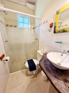 a bathroom with a sink and a toilet and a shower at Pousada Por do Sol in Ilhabela