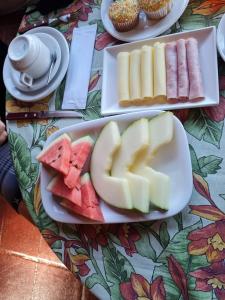 una mesa cubierta con tres platos de comida con fruta en Pousada Por do Sol, en Ilhabela