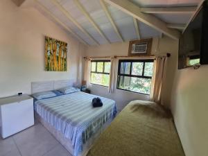 a bedroom with a bed and two windows at Pousada Por do Sol in Ilhabela +37 photos