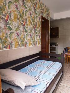 uma cama num quarto com uma parede colorida em Pousada Recanto do Norte em Florianópolis
