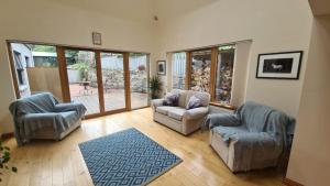 sala de estar con 2 sillas y sofá en Milne's Brae, cosy, comfortable and centrally located in beautiful Braemar, en Braemar