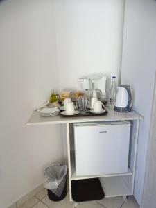 a small kitchen with a table with dishes on it at Artemis GreenHill in Vravrona