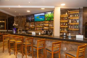 a bar in a restaurant with wooden stools at Hotel Chalés Capitanias in Águas de Lindoia
