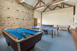 two pool tables in a room with a stone wall at Crib Goch Cottage in Llanfairpwllgwyngyll