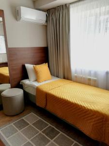 een slaapkamer met 2 bedden en een raam bij Отель Ле Мон in Stavropol
