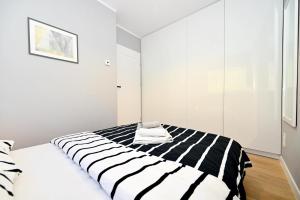 シュチルクにあるSzczyrk Apartament Miętowy z balkonem - Słoneczna Góraのベッドルーム(黒と白のストライプのベッド1台付)