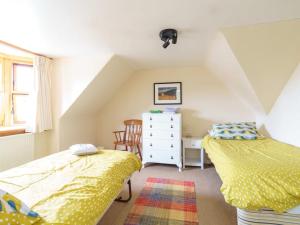a attic bedroom with two beds and a dresser at Milne's Brae, cosy, comfortable and centrally located in beautiful Braemar in Braemar