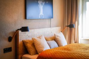 a bedroom with a bed with pillows and a painting on the wall at Allgäu Chalet mit Berg-Panorama in Oberreute