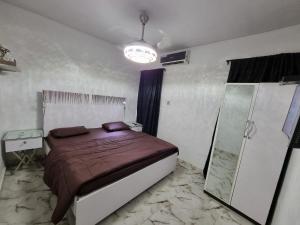a bedroom with a bed and a glass shower at CG Apartments in Ikeja