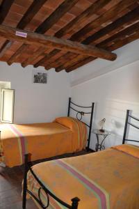 a bedroom with three beds and a wooden ceiling at Corte Prata in Capannori