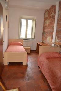- une chambre avec 2 lits et un mur en briques dans l'établissement Corte Prata, à Capannori