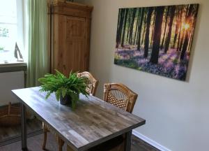 a dining room table with a painting on the wall at The Cozy Cottage in Rieden