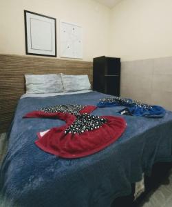 una camera da letto con un letto con un copriletto blu con una coperta rossa di Flat Porto a Porto De Galinhas