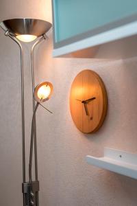 a wooden clock on the wall next to a lamp at Family apartments in Sortavala