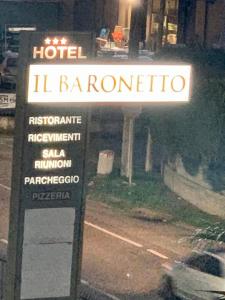 a sign for a hotel in front of a building at Hotel Il Baronetto in Tarsia