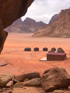 un groupe de bâtiments dans un désert avec des montagnes dans l'établissement Star Walk Camp & Tours, à Wadi Rum