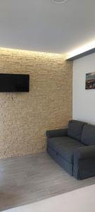 a living room with a couch and a brick wall at Top Location in Živogošće