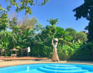 uma mulher de vestido ao lado de uma piscina em Oriental Siam Resort - SHA Extra Plus Certified em Chiang Mai