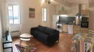 a living room with a couch and a kitchen at Au coeur des boulevards À 2 pas des chemins de rando in Céret