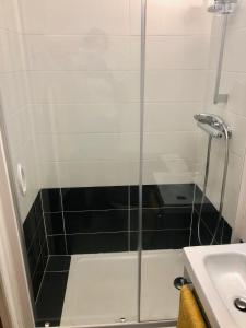 a glass shower in a bathroom with a sink at Au coeur des boulevards À 2 pas des chemins de rando in Céret