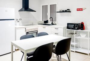 una cucina bianca con tavolo e sedie bianchi di N&V San Anton a Granada