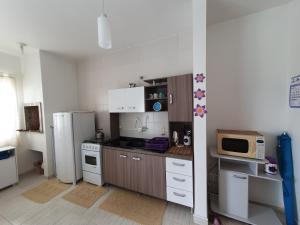 una cocina con nevera y microondas en Apto Solar da Praia, en Piçarras