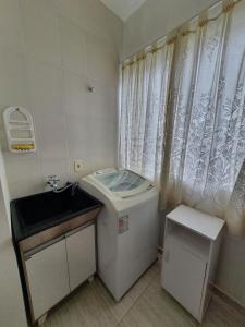 Un baño pequeño con inodoro y lavabo. en Apto Solar da Praia, en Piçarras