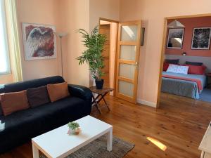 un salon avec un canapé et un lit dans l'établissement Le Patio maison de charme 150m plage et hyper centre, à La Rochelle