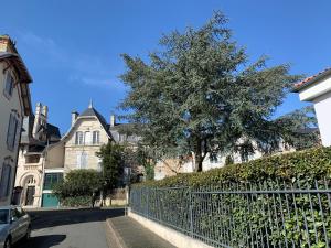 une clôture devant une maison avec un arbre dans l'établissement Le Patio maison de charme 150m plage et hyper centre, à La Rochelle