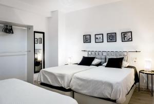 2 letti in una camera con pareti bianche di N&V San Anton a Granada
