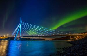 a bridge with the northern lights in the sky at Mix Tana Spiseri og Overnatting in Tana