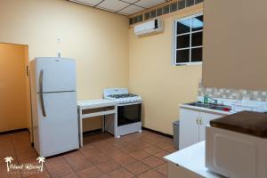 a kitchen with a white refrigerator and a stove at Yellow Belly Backpackers in San Ignacio