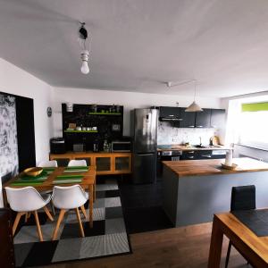薩爾布呂肯的住宿－FULL FLAT 3 BEDROOMS SAARBRUCKEN CENTER -11 PEOPLE，厨房以及带桌椅的用餐室。